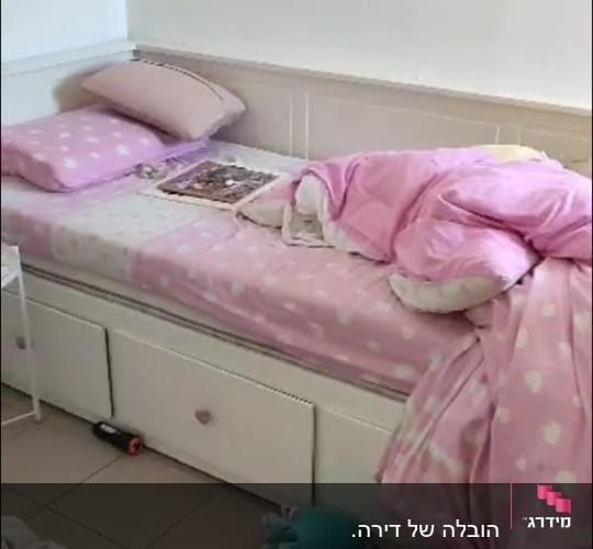 מיטה עם מצעים ורודים, כרית על הרצפה
